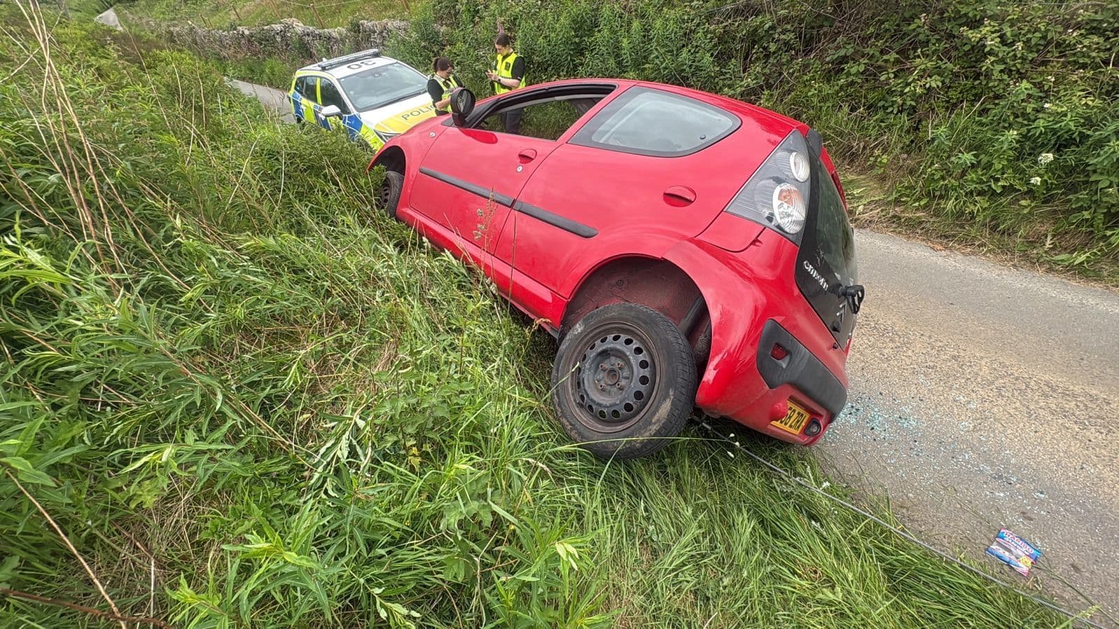 A red car recovered from a grass verge with police in attendance